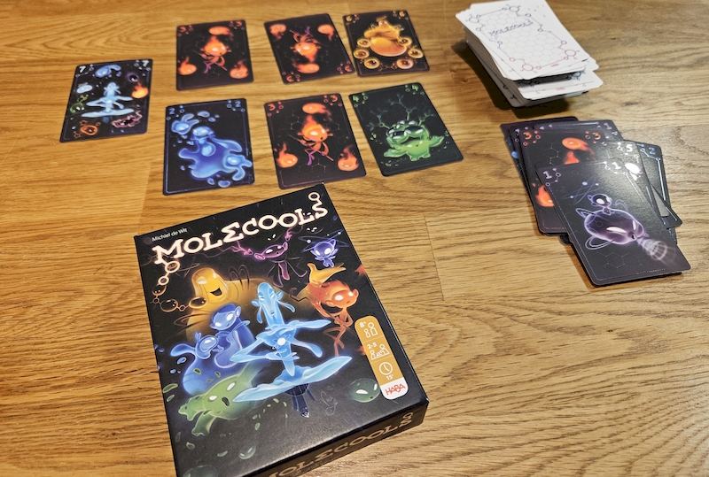 Spieleschachtel mit Karten des Kartenspiels Molecools